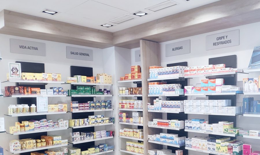 Estanterías de una Farmacia Amiga señalizadas por categorías: vida activa, salud general, alergias, gripe y resfriados, dolor o fiebre.
